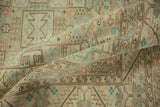 Folded corner of a distressed Sparta carpet showing the low pile texture and repeating shield design.