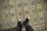 Low pile texture on a distressed Kayseri with alternating floral panels in slate blue and sand.