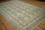 Angled view of a distressed Kayseri carpet's repeating panel design in slate blue and antique ivory.