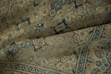Time-softened texture of a distressed Turkish carpet with navy and slate blue floral details.