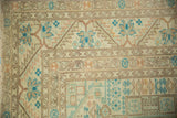 Close-up of the distressed Sparta carpet's corner, showing its geometric serrated leaf and floral borders.