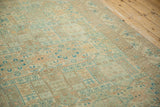Low, even wear on the vintage Sparta carpet's geometric shield medallions in sea foam and blue tones.