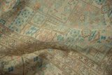 Distressed hand-knotted texture of a Sparta carpet with geometric designs in sea foam and copper.