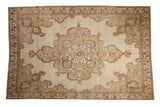 Vintage distressed Kars carpet with a shield-like center medallion in neutral beige and sand tones.