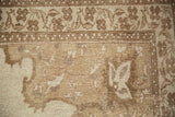 Even wear to the knot heads on a distressed Kars carpet corner in shades of beige and sand.