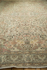 Distressed Sparta carpet with traditional ivory, rose, chocolate vines; mostly even wear across knot heads.