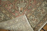 Distressed Sparta rug corner showing machine-bound edge, reverse, and worn rose, ivory patterns.