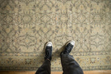 Distressed Sivas carpet featuring faded diamond vine pattern, subtle pale green, and footwear.