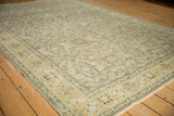 Angled corner view of a distressed Sivas carpet, highlighting palmette border motifs and faded field vines.