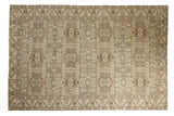 Vintage distressed Sparta carpet with a geometric shield medallion pattern in neutral tones of ivory, beige, and brown.