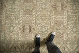 A look down at the distressed vintage Sparta carpet, showing its low-pile texture and repeating shield motifs.