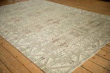 Angled view of a distressed Sparta carpet's geometric field and serrated leaf border.
