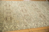 Time-softened low pile and geometric motifs on a vintage distressed Sparta carpet from an angled view.