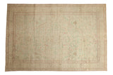 Distressed Kayseri carpet with a starburst medallion and pale floral accents in mint and magenta.