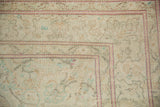 Corner of a distressed Kayseri carpet with a pale magenta border, showing mostly even wear to the knot heads.