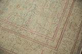 Worn, low-pile texture and raspberry red border on a distressed vintage Kayseri carpet corner.