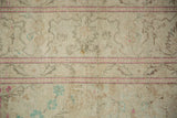 Distressed low-pile texture of a vintage Kayseri carpet with raspberry red and mint green details.