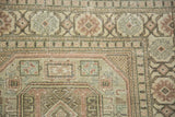 Evenly worn pile showing geometric florals in dusty rose and ocean green on a Sparta carpet corner.