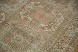 Distressed low pile and geometric guls in rose and green on a vintage Sparta carpet.