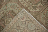 Folded corner of a distressed Sparta carpet showing its hand-knotted reverse and bound edge.