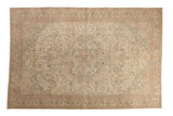 Distressed vintage Sparta carpet with a roundel medallion and scrolled vines in cream, blush, and pale brown.