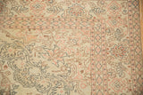 Corner detail of a distressed Sparta carpet with blush and brown scrolled vines over a worn, low pile.