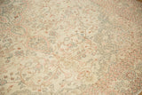 The mostly even wear and low pile texture of the vintage carpet's sprawling floral vines.