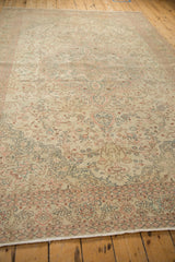 Angled perspective of a vintage Sparta carpet highlighting its sprawling floral vines and distressed texture.