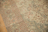Hand-knotted texture of the distressed Sparta carpet, with scrolled vines and faded blush floral borders.