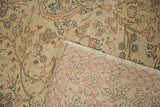 A folded corner on the vintage Sparta carpet reveals its hand-knotted construction and distressed pile.