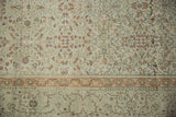 Close view of the distressed hand-knotted pile showing floral vines and the sandalwood border.
