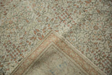 Folded corner of a distressed Kayseri carpet revealing its hand-knotted foundation and bound edge.
