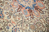 Vintage Kayseri carpet detail with ivory field, terracotta, and sapphire blue floral arabesque.