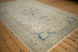 Angled view of a distressed Kayseri carpet with a low pile and scrolling floral borders.