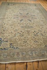 Perspective view down a distressed Kayseri rug showing its low pile and scrolling vine motifs.