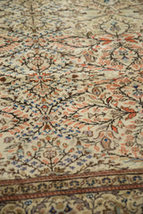 Close-up of vintage Sparta carpet with delicate terracotta, sapphire blue vines, and scrolled tendril border.