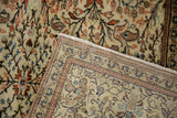 Close-up of Sparta carpet's hand-knotted foundation, machine-bound edge, and delicate floral vines.