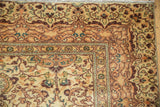 Turkish Kayseri rug corner with beige floral field and neat machine-bound edge.