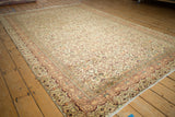 Vintage Kayseri carpet close-up, highlighting cream floral blossoms, aubergine, tangerine, and machine-bound edge.