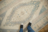 A look down at the distressed low pile and stepped slate blue center medallion of a vintage Oushak rug.