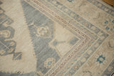 Detail of the distressed texture and stepped contour of a vintage Oushak in slate blue and sand.