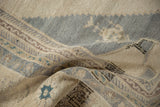 The low, hand-knotted pile and even wear of a distressed Turkish Oushak carpet in sand and slate blue.