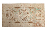 Vintage distressed Sparta carpet with a bold medallion in soft ivory, coffee brown, and pale green tones.