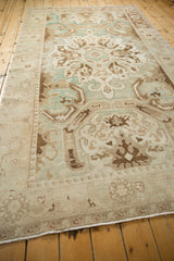 Angled perspective across the distressed pile and Herati border of a vintage Turkish Sparta carpet.