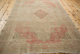 Kayseri rug side edge showing intact selvage, muted pink motifs, and even distressed wear.