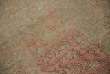 Faded pink floral motifs and textured, mostly even wear on this vintage Kayseri rug.