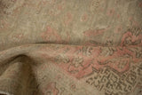 Worn pile and muted pink geometric patterns on a distressed vintage Kayseri rug.