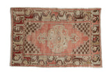 Hand-knotted distressed vintage Oushak rug with faded blush medallion and burgundy floral border.
