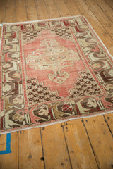 Distressed Oushak rug with time-softened blush field and beige floral arabesque border.