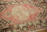 Distressed Oushak rug corner detail: beige lattice blossoms on blush field with floral border.